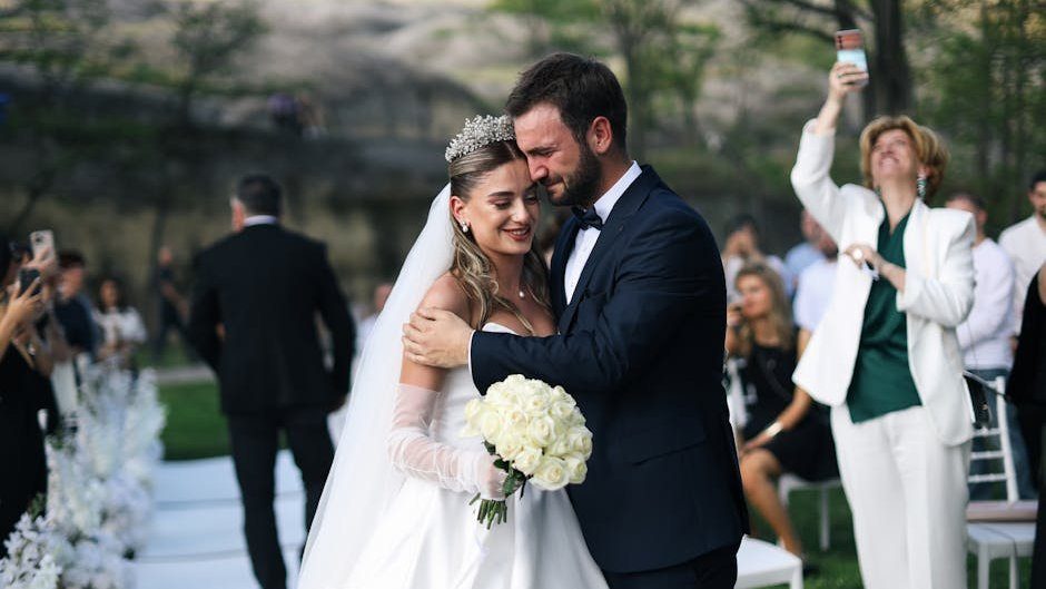 Beautiful outdoor wedding ceremony featuring a happy bride and groom embracing.